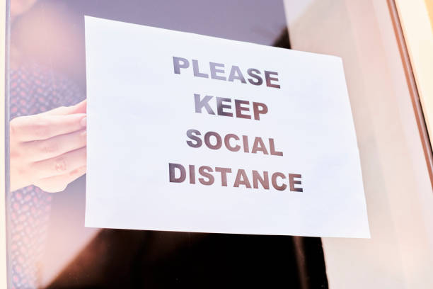 istock Shop or restaurant worker hanging a warning sign 1225787334