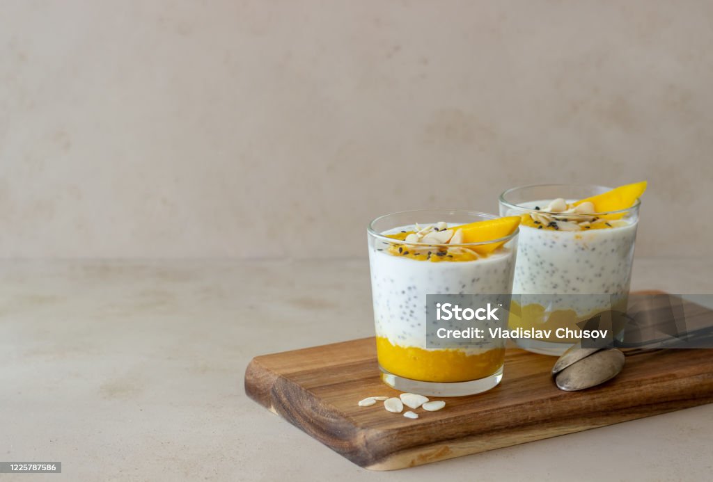 Yogurt in a glass with mango, chia and almonds. Healthy eating. Vegetarian food. Recipe. Breakfast. Diet. Yogurt in a glass with mango, chia and almonds. Healthy eating. Vegetarian food. Recipe. Breakfast. Diet Dessert - Sweet Food Stock Photo
