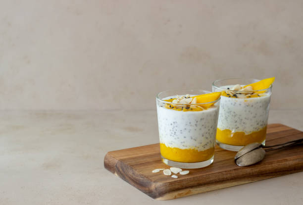 Yogurt in a glass with mango, chia and almonds. Healthy eating. Vegetarian food. Recipe. Breakfast. Diet. Yogurt in a glass with mango, chia and almonds. Healthy eating. Vegetarian food. Recipe. Breakfast. Diet mango fruit photos stock pictures, royalty-free photos & images