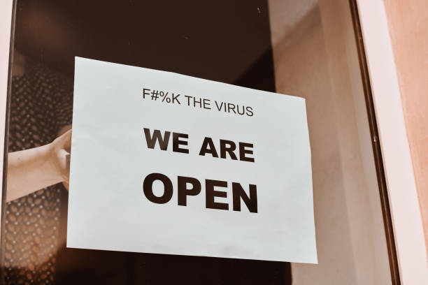 istock Shop or restaurant worker hanging a paper sign 1225789956