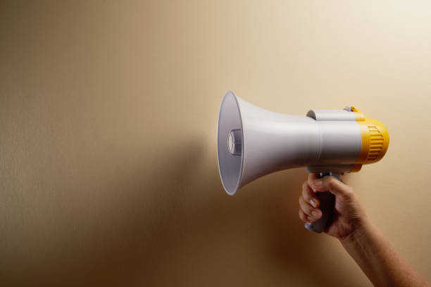 istock women's hand holding megaphone 1225790083