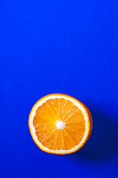 istock Half an orange close-up on classic blue background. 1225790296