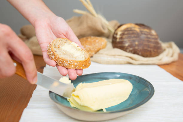 istock Woman cutting butter for spreading onto slice 1225790708