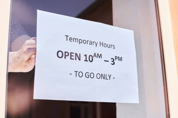 istock Shop or restaurant worker hanging a warning sign 1225790832