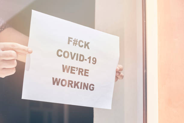 istock Shop or restaurant worker hanging a paper sign 1225791470