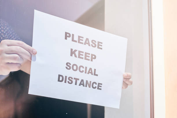 istock Shop or restaurant worker hanging a warning sign 1225791660
