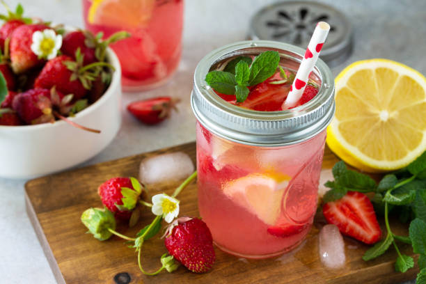 istock Summer drink refreshing. Lemonade with fresh strawberries, ice and lemons on a light stone countertop. 1225791685