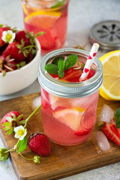 istock Summer drink refreshing. Lemonade with fresh strawberries, ice and lemons on a light stone countertop. 1225791688