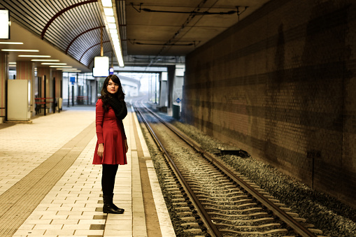 tourist woman  standing on the platform of railway station .