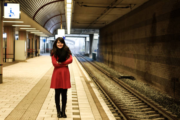 tourist woman  standing on the platform of railway station .