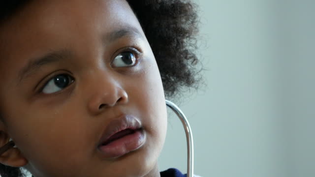 African-American Ethnicity little boy try to wearing medical stethoscope