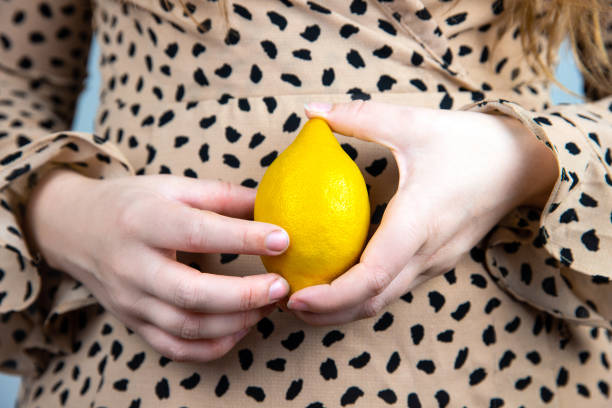 jovem linda mulher segurando um limão amarelo fresco em suas mãos, close-up conceito de fruta de verão - close up women horizontal citrus fruit - fotografias e filmes do acervo