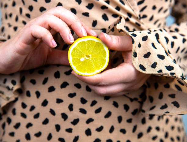 giovane bella donna che tiene un limone giallo fresco tra le mani, concetto di frutta estiva ravvicinata - close up women horizontal citrus fruit foto e immagini stock