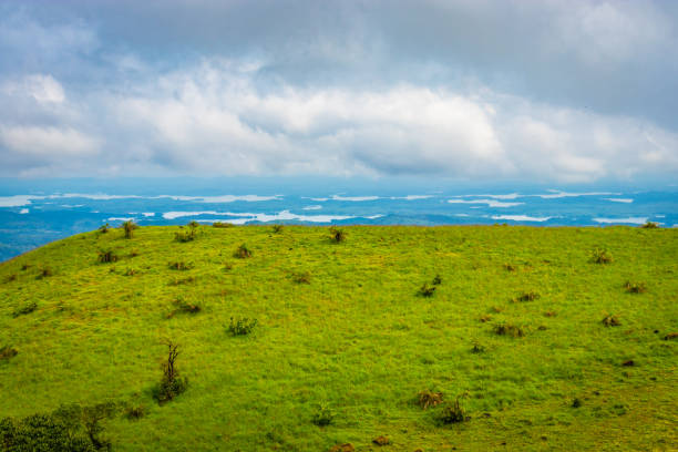 mountain with green grass and thick clouds image is showing the amazing beauty and art of nature. This image is taken at karnataka india from hilltop.