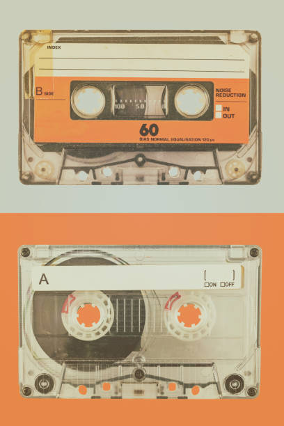 istock Two old audio compact cassettes on a blue with orange background 1225797080