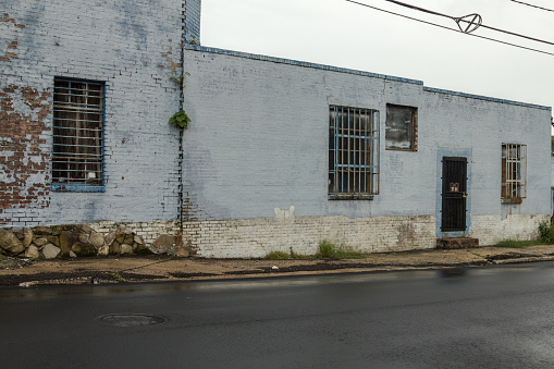 Side of old vintage warehouse building painted light blue in urban Atlanta on dreary day