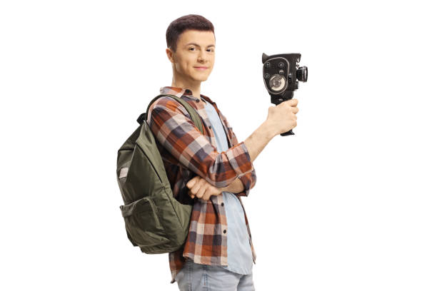 istock Male student with a backpack holding a vintage 8mm camera 1225800097