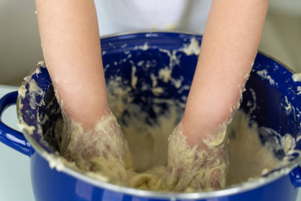 istock Baby kneads dough in a saucepan 1225800758