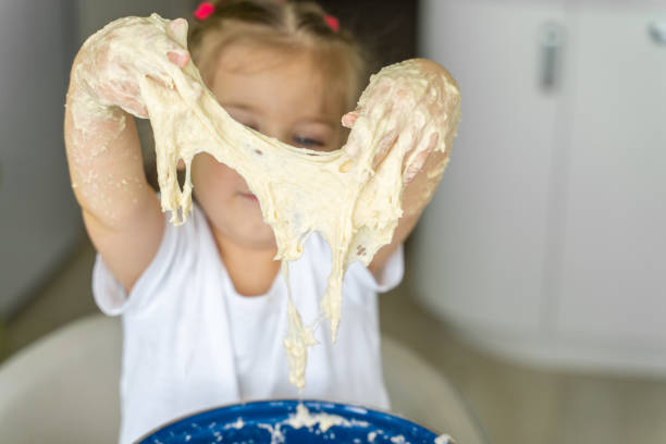 istock Baby kneads dough in a saucepan 1225800784