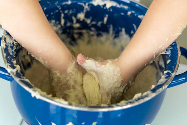 istock Baby kneads dough in a saucepan 1225800831