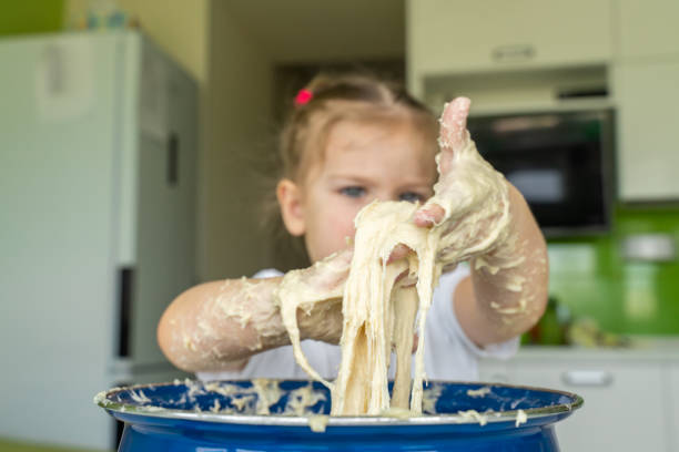 istock Baby kneads dough in a saucepan 1225800845