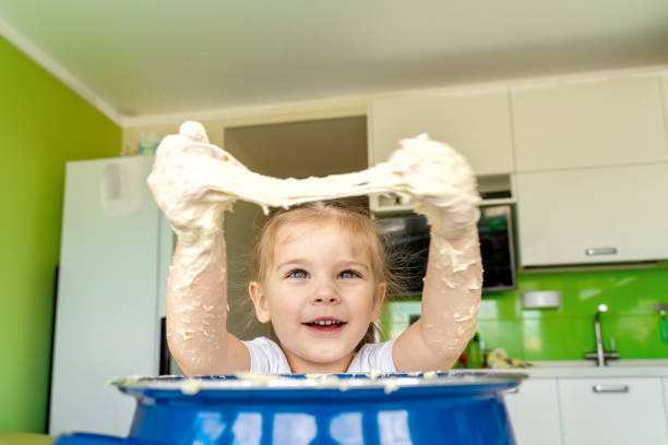 istock Baby kneads dough in a saucepan 1225801002