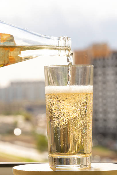 sparkling water is poured into a glass, sparkling bubbles in a glass