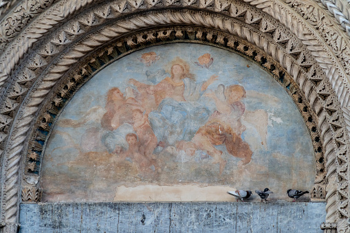 Atri, Teramo, Italy, August 2019: Fresco above the gate of the Cathedral of Atri, Basilica of Santa Maria Assunta, national monument since 1899, Gothic architecture