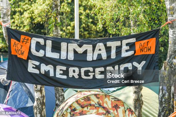 Climate Emergency Banner Hung Between Trees In A Makeshift Campsite In Cardiff City Centre As Part Of The Climate Change Protest By Extinction Rebellion Stock Photo - Download Image Now