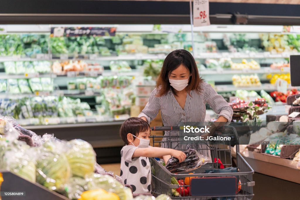 Mother and son wearing face masks shopping together in a supermarket Mother and son wearing face masks shopping together in a supermarket. Okayama, Japan Supermarket Stock Photo