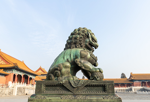 Golden Chinese lion steps on the ball at Forbidden city, BEIJING, China.