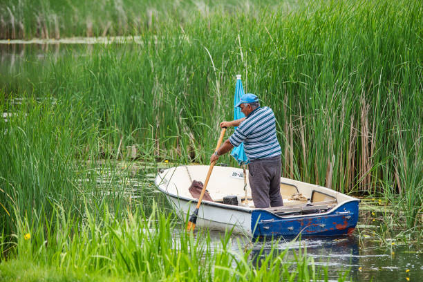 traditional Rhein fishing boat moored on the shore of the Nature conservation area TaubergiessenBaden Germany