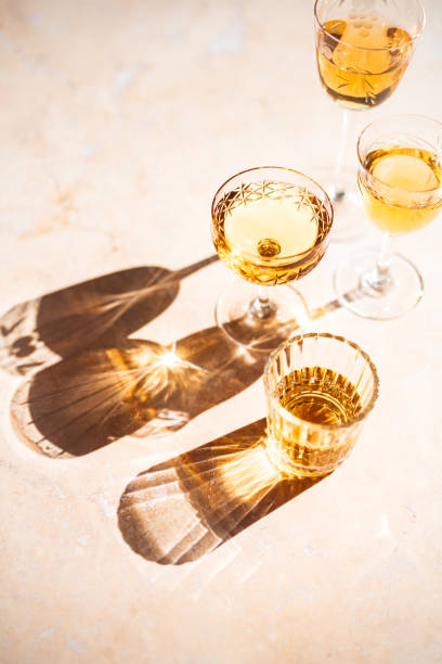 reflections of wine filled vintage glasses - illuminated vertical shadow focus on shadow imagens e fotografias de stock