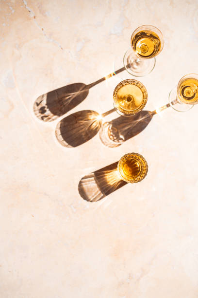 reflections of wine filled vintage glasses - illuminated vertical shadow focus on shadow imagens e fotografias de stock