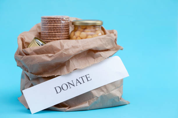 istock paper bag with donate food on blue background 1225812539