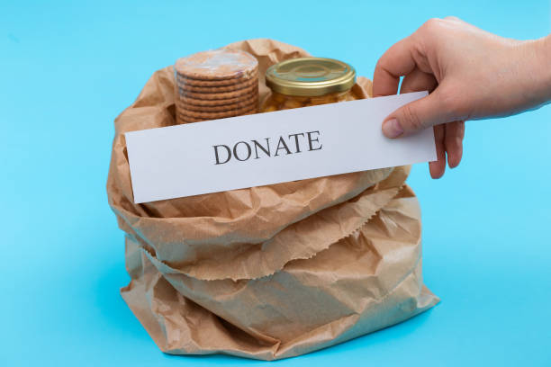 istock paper bag with donate food on blue background 1225812544