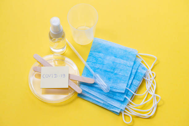istock medical mask, plastic cups and other objects on yellow background 1225813135