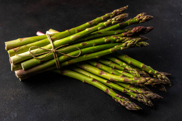 istock View of fresh asparagus on a black table. Food background. 1225813792