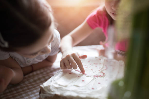 Kids decorate the cake in the kitchen