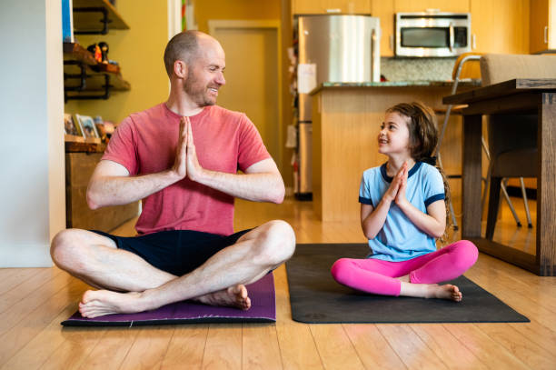 istock Father and daughter doing home yoga during lockdown 1225818240