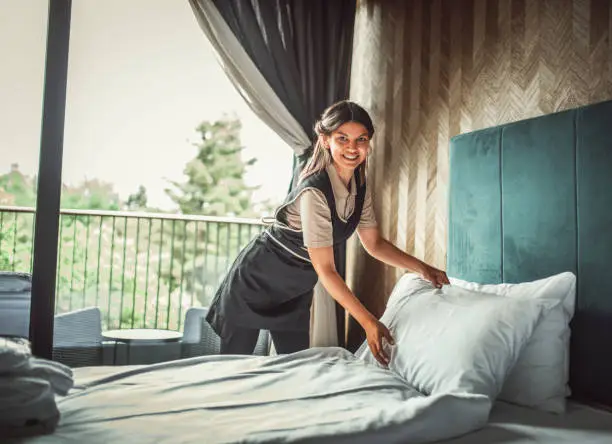 Housekeeper making the bed at a hotel