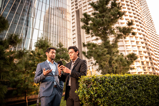 Mexican and Indian businessmen having a talk in business district