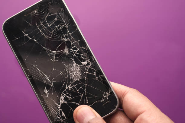 istock hand holding broken smart phone on color background 1225820670