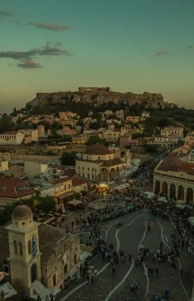 A picture of Monastiraki Square overlooked by the Acropolis of Athens, at sunset.