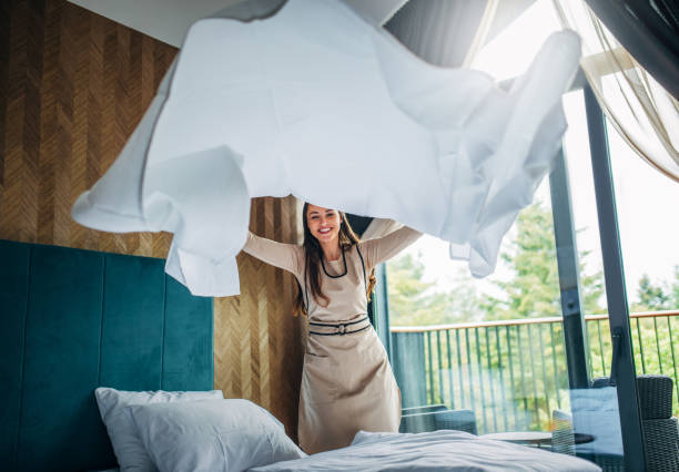 Housekeeper making the bed at a hotel stock photo