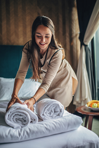Housekeeper making the bed at a hotel