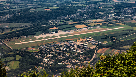 Close-up of Chambery french city airport near Bourget lake. This photo was taken during a sunny summer day from the top of La Dent Du Chat mountain peak in end of Bugey mountains, European Alps in border of Ain and Savoie department, near Aix-les-Bains famous city on the shore of Lake Bourget in Auvergne-Rhone-Alpes region in France, Europe.