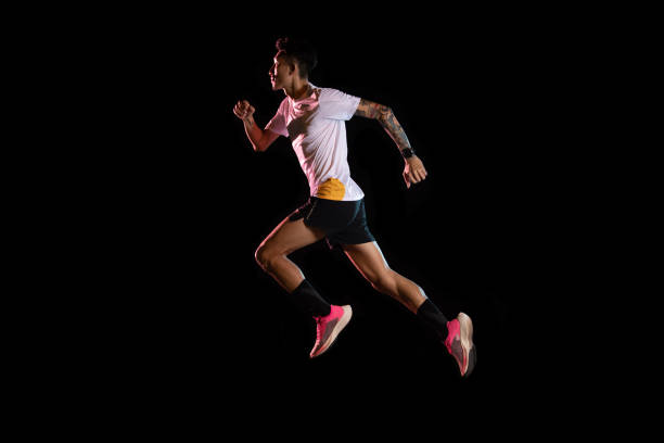 istock Asian man young sprinter runner running in studio on black background 1225824882