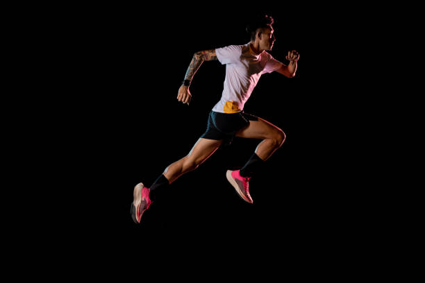 istock Asian man young sprinter runner running in studio on black background 1225824886