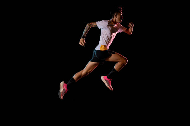 azjatycki mężczyzna młody sprinter biegacz działa w studio na czarnym tle - muscular build sprinting jogging athlete zdjęcia i obrazy z banku zdjęć